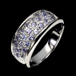 CLÁSSICO ANEL PAVÊ EM PRATA DE LEI ESPESSURADA A OURO BRANCO, DESIGN EXCLUSIVO DE EXCEPCIONAL OURIVESARIA COM PRECIOSA CRAVAÇÃO DE TANZANITAS DE LAPIDAÇÃO  BRILHANTE, ADORNADAS POR RICO TRABALHO E FINO ACABAMENTO. PERFEITO ESTADO DE CONSERVAÇÃO, SEM USO. ARO MEDE 1,9 CM, ARMAÇÃO 2,1 X 0,8 CM. ORIGEM TANZÂNIA.