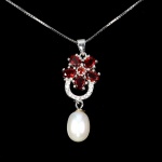 Elegante colar em prata de lei espessurada a ouro branco, design floral exclusivo de excepcional ourivesaria. Pingente com bela cravação de Rodolitas de 4.0 x 3.0 mm, clássica lapidação oval brilhante, adornada por elegante guirlanda de Zirconias extra brancas, rico trabalho e linda Pérola de 8.0 mm. Perfeito estado de conservação, sem uso. Corrente com clássica malha veneziana, mede 45 cm, pingente 3,4 x 1,2 cm. Origem Moçambique e Tailândia.