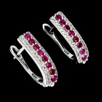 Belíssimo par de brincos em prata de lei espessurada a ouro branco, design exclusivo de excepcional ourivesaria com preciosa cravação de Rubis de 2.0 mm, clássica lapidação brilhante, adornados por rico trabalho e fino acabamento com elegante guirlanda de Zirconias extra brancas. Perfeito estado de conservação, sem uso. Medem 1,6 x 0,4 cm. Origem Moçambique, África.