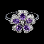 Belíssimo anel em prata de lei espessurada a ouro branco, design moderno floral exclusivo de excepcional ourivesaria com preciosa cravação de Ametistas de 4.0 x 3.0 mm, clássica lapidação oval brilhante, adornadas por rico trabalho e majestosa coroa de Zirconias extra brancas. Perfeito estado de conservação, sem uso. Aro mede 1,8 cm, armação 1,6 x 1,4 cm. Origem Uruguai e África.