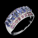 CLÁSSICA E BELÍSSIMA MEIA ALIANÇA EM PRATA DE LEI ESPESSURADA A OURO BRANCO, DESIGN EXCLUSIVO DE EXCEPCIONAL OURIVESARIA COM PRECIOSA CRAVAÇÃO DE TANZANITAS DE 5.0 X 2.5 MM, CLÁSSICA LAPIDAÇÃO MARQUISE BRILHANTE, ADORNADAS POR RICO TRABALHO E FINO ACABAMENTO COM RODOLITAS DE LAPIDAÇÃO DIAMANTE. PERFEITO ESTADO DE CONSERVAÇÃO, SEM USO. ARO MEDE 1,9 CM, ARMAÇÃO 1,8 X 0,8 CM. ORIGEM TANZÂNIA E MOÇAMBIQUE.
