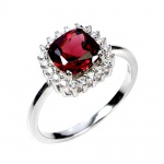 Belíssimo anel em prata de lei espessurada a ouro branco, design exclusivo de excepcional ourivesaria com preciosa Granada Rodolita extra de 7.0 mm, clássica lapidação almofada brilhante, adornada por rico trabalho e fino acabamento com majestosa coroa de Zirconias extra brancas. Perfeito estado de conservação, sem uso. Aro mede 1,7 cm, armação 1,0 cm. Origem Moçambique, África.