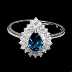 Belíssimo anel em prata de lei espessurada a ouro branco, design exclusivo de excepcional ourivesaria com precioso Topázio London blue extra de 7.0 x 5.0 mm, clássica lapidação pera brilhante, adornado por rico trabalho e fino acabamento com majestosas coroas de Zirconias extra brancas de lapidações baguete e diamante. Perfeito estado de conservação, sem uso. Aro mede 1,8 cm, armação 1,4 x 1,2 cm. Origem África.