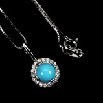 Belíssimo colar em prata de lei espessurada a ouro branco, design exclusivo de excepcional ourivesaria. Pingente com linda Turquesa azul extra de 6.0 mm, clássica lapidação cabochon, adornada por rico trabalho e fino acabamento com elegante coroa de Zirconias extra brancas. Perfeito estado de conservação, sem uso. Corrente com clássica malha veneziana, mede 45 cm, pingente 1,6 x 1,0 cm. Origem Brasil.