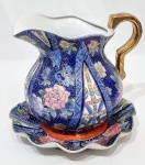 CHINA - Lindo conjunto dito gomil, composto por um presentoir e uma jarra. Executadas finamente em porcelana de ótima qualidade e manufatura oriental. Adornadas por riquíssimo trabalho floral com filetes e coberturas á ouro. Presentoir com borda tiotada. Perfeito estado de conservação. Mede 23,0 cm de altura x 25 cm de diâmetro da bandeja.