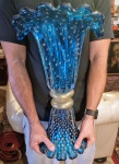 MURANO - Grandioso e magnífico vaso em vidro artístico de Murano, design exclusivo com borda dita Napoleão, feitio gomado com bolhas e pó de ouro espalhado, rica tonalidade azul safira. Mede 49,0 cm de altura x 30,0 cm de comprimento da borda x 25,0 cm de largura da borda x 24,5 cm de diâmetro da base. Perfeito estado de conservação.
