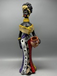 DECORAÇÃO - Escultura de cerâmica Caruaru, representando mulher africana com xale dourado, rica em detalhes na vestimenta e no arranjo de cabelos. Med. 45x16 cm.