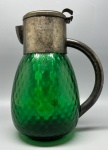 DEMI CRISTAL - Antiga jarra para sucos com lapidação em ondas, na cor verde esmeralda, dotada de suporte interno para gelo.  Possui alça e tampa de metal espessurado a prata.  Falta o pino que prende a tampa. Med. 27x20 cm.