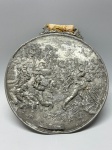 WMF  Cena Campestre em Baixo-Relevo - Antiga placa redonda em pewter espessurado da renomada manufatura alemã WMF (Württembergische Metallwarenfabrik), com rica cena de colheita e trabalho rural em campo aberto. A composição em alto e baixo-relevo apresenta lavradores em ação, construções ao fundo e vegetação minuciosamente detalhada, compondo um autêntico registro de vida campestre europeia do século XIX. A peça preserva o medalhão com inscrição WMF na base e traz vestígios da antiga fita de suspensão ornamental. Med. 16 cm. Desgastes.