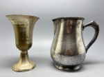 METAL  Lote com jarra e vaso (2 peças), lote composto por duas peças antigas em metal espessurado:  Jarra de corpo bojudo, bico levemente moldado e alça firme, com acabamento espelhado escurecido e marcas do tempo visíveis, ideal para ambientações clássicas ou uso decorativo e Vaso tipo trombeta, de linhas suaves e base circular elevada, com pátina dourada envelhecida e forma elegante  ideal para arranjos florais ou composição de aparador.  Alt. 19 cm. Desgastes.