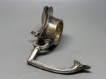 METAL - BOCAL  Antigo bocal em metal espessurado para jarra ou licoreira - Peça de encaixe em metal espessurado a prata, destinada a jarra ou licoreira antiga. Corpo com bojo arredondado e ornamentação em curvas orgânicas no estilo Art Nouveau, além de alça decorada com frisos e folha em relevo no terminal. Elemento de reposição ou uso criativo em restauração e decoração. Med. 15x15 cm. Desgastes.