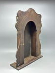 RELÓGIO - Antiga caixa de relógio de mesa no estilo "capelinha", entalhada em madeira com ornamentos em relevo e formato curvo na parte superior. Peça de época, ideal para restauração ou uso decorativo. Med. 44x34x10 cm. Necessita restauro.