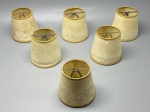 ILUMINAÇÃO  Conjunto com 6 cúpulas antigas em pergaminho sintético, para abajures ou arandelas.Estrutura em metal e revestimento em material translúcido de cor bege, com acabamento dourado na borda superior. Peças com pátina evidente, manchas e sinais de envelhecimento  ideais para restauração ou ambientações com estética vintage/autêntica.Med. 10X9 cm cada.