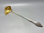 WMF - Antiga concha WMF, produzida pela tradicional manufatura alemã Württembergische Metallwarenfabrik, em metal prateado com banho dourado no interior do bojo. A peça apresenta cabo decorado com elegantes elementos em estilo art nouveau e forma angulada pouco comum no bojo, conferindo-lhe um caráter decorativo e funcional. Gravada com a marca WMF I/O, que indica a aplicação eletrolítica de prata, é um belo exemplo da refinada produção de utilitários de mesa do início do século XX. Med. 42x8,9x11 cm. Marcas do tempo.