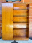 MOBILIÁRIO - ARMÁRIO MODERNO COM PRATELEIRAS ABERTAS  DÉCADA DE 1950/60Armário em madeira nobre com design funcional e linhas retas típicas do modernismo brasileiro. Estrutura com uma porta lateral que oculta prateleiras internas e parte aberta com cinco prateleiras fixas. Ideal para uso como estante, sapateira ou armário multiuso. Peça vintage, com acabamento original em bom estado geral e pátina do tempo preservada.Medidas aproximadas: 206x150x50 cm.