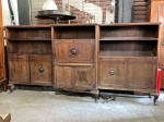 MOBILIÁRIO - RARO MÓVEL BIBLIOTECA / BAR EM MADEIRA NOBRE  ESTILO CLÁSSICOGrande e elegante móvel em madeira escura, com três módulos integrados, combinando estantes abertas, armários inferiores com portas almofadadas e seção central com bar embutido ou secretaria com porta basculante. Detalhes entalhados em baixo-relevo nas portas e frentes, puxadores centrais circulares em relevo floral e pés cabriolet, típicos do estilo francês. Peça robusta, ideal para biblioteca, sala de estar ou ambiente sofisticado. Necessita leve restauro ou limpeza, com estrutura sólida e grande potencial decorativo.Medidas aproximadas: 140x290x48 cm.