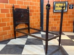 MOBILIÁRIO - ANTIGA CAMA ANTIGA EM MADEIRA NOBRE - Imponente estrutura de cama de época, confeccionada em madeira escura de lei, exalando a robustez e o requinte do mobiliário clássico. A peça é composta por uma cabeceira alta com detalhe central entalhado e molduras ornamentadas, ladeada por elegantes pináculos torneados. A peseira apresenta quatro robustos postes com pináculos superiores, sugerindo uma estética de cama com dossel ou uma presença marcante no ambiente. Ideal para projetos de restauração, completando sua estrutura com estrado e laterais para um uso pleno, ou para que suas belas peças sejam reutilizadas como elementos decorativos singulares. Em ótimo estado estrutural, com a pátina e marcas do tempo que atestam sua autenticidade. Med. 206x178x100 cm.