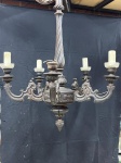 ILUMINAÇÃO - LUSTRE ANTIGO DE CINCO BRAÇOS EM MADEIRA ENTALHADA - Imponente lustre de teto, uma peça de rara beleza que evoca a grandiosidade dos salões clássicos. Confeccionado em madeira escura, ricamente entalhada, apresenta cinco braços curvilíneos adornados com detalhes ornamentais. O corpo central e a coluna superior destacam-se pelos seus trabalhos entalhados e formações robustas. Perfeito para adicionar um toque de elegância e história a salas de jantar, halls de entrada ou ambientes que buscam uma iluminação com personalidade e caráter. A peça necessita de revisão elétrica para pleno funcionamento. Med. aprox. 120x75 cm.