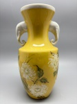 PORCELANA - Lindo vaso floreira em porcelana branca, pintado a mão em tom ocre, decorado crisantemo, alças laterais em formato de cabeças de elefantes. Alt. 26 cm.