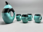 FAIANÇA - Conjunto de jarra e 4 canecas em faiança, esmaltada em tom azul e preto, decorado com escorridos, alças vazadas. Med. 27 cm e 11 cm. Bicados.