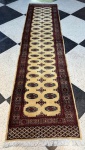 TAPETE - Passadeira Paquistanês Artesanal Karachi. Med. 270x75 cm. Cores predominante bege e vermelho. Marcas do tempo.