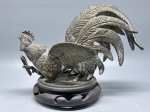 DIVERSOS - Galo de briga em bronze espessurados a prata, adaptado sobre peanha de madeira. Med. 20x25x15 cm.