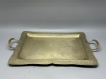 METAL - Antiga bandeja retangular em metal espessurada a prata, fundo martelado e borda lavrada, alças laterais. Med. 53x44x30 cm. Marcas do tempo e de uso.