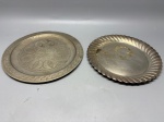 METAL - Lote de 2 bandejas redondas em metal espessuradas a prata, modelos diferentes, sendo uma com o fundo lavrado e outra com a borda retorcida. Med. 25 cm e 23,5 cm. Marcas do tempo e de uso.