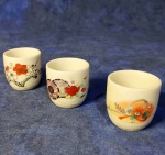 SAKAZUKI - Três pequenos bowls em porcelana branca, decorados com diferentes ilustrações florais. Antigos recipientes japoneses, para serviço de saquê em pequenas  quantidades. Tradicional em reuniões de trabalho ou eventos familiares religiosos Onde o consumo é simbólico Origem - Japão. Medem 4 x 4 cm. Sem uso anterior.
