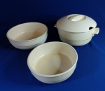 CERÂMICA - Lindo jogo para serviço de mesa, composto por sopeira com tampa de duas travessas redondas, em cerâmica esmaltada na cor bege. Medidas: Sopeira - 12 cm de altura e 20 cm de diâmetro; Travessa com 8 cm alt e 22 m de diâmetro e travessa com 7 cm de alt e 20 de diâmetro. Mínimas marcas do tempo.