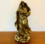 MADONA - Importante conjunto escultórico representando a Madona com menino Jesus, rodeada de anjos aos seus pés. Em resina italiana e revestida em folhas de ouro, mede 45 cm de altura. Cena sacra tradicional. Importada.