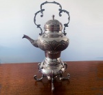 ANTIGUIDADE - Imponente  Samovar de origem russa, utensilio usado para aquecer água e chá.  Confeccionado artesanalmente em metal espessurado a prata, com ilustrações de folhas e volutas, medindo 44 cm. Mínimas marcas do tempo.