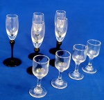CRISTAL/VIDRO - Lote com dois jogos de taças, o primeiro em vidro, medindo 9 cm de altura, apropriados para licor, quatro peças; o segundo, em cristal duo color, liso e verde escuro, medindo 15 cm de altura, para vinho do Porto, cinco peças. Total do lote nove peças.