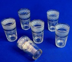 VENEZIANOS - Conjunto com seis pequenos copos de vidro, para aperitivos. Lindíssimos detalhes decorativos, ao estilo veneziano, conferem classe e beleza ao jogo. Medem 9 x 5 cm.