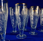 CRISTAL - Magníficas tulipas com 20 cm de altura, num primoroso estilo bisotado em fino cristal europeu, com acabamento de ouro filetando as bordas. Total de 16 peças, medem 7 cm de diâmetro na boca.
