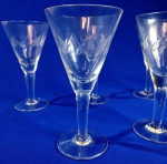 CRISTAL - Lindas taças cônicas em fino cristal bisotadas com folhas. Total de cinco peças medindo 15 cm de altura e oito de boca. Uma peça com mínimo bicado.