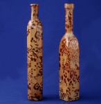 AFRICA - Par de garrafas em grosso vidro, decoradas com pintura no padrão das onças pintadas. Medem 32 cm de altura e 5 x 5 cm de base.
