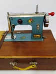 Antiga máquina de costura infantil em ferro , marca BAMBI na base caixa de madeira. Não testada.