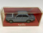 Miniatura de carrinho de maquete Harpa modelo Ford Escort, cinzento azulado. Na embalagem, mede aproximadamente 2x6 cm.