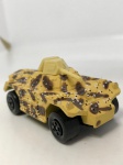 Miniatura veículo tanque militar, com camuflagem em amarelo e marrom. Mede aproximadamente 7x2,5. (sem caixa)