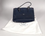 Prada. Bolsa em couro azul marinho ornado com aplique da logomarca em metal cromado. Base reforçada
