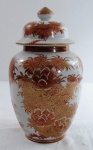 Potiche em porcelana oriental da década de 1950 com decoração floral nos clássicos tons rouge de fer e dourações. Med. 25 cm alt.