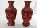 Par de antigos vasos em laca chinesa no tom vermelho, decorado com florais  e guirlandas em relevo, Século XIX, acompanha peanhas em madeira. Med. 19 cm alt.
