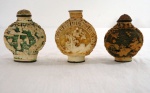 SNUFF BOTTLE- Três (03) Antigos frascos de perfume Chinês no tom marfim frasco Rapé, decorado em relevo com figuras típicas e pagodes em laca esculpidas ã mão, assinada na base com ideogramas. Um falta a tampa. Med. 6,5 cm alt. foram usadas pelos chineses durante a dinastia Qing para conter tabaco em pó. Fumar tabaco era ilegal durante a Dinastia Qing, hábito que foi introduzido pelos colonizadores portugueses ainda no sec. XVI. Mas o uso de rapé foi permitido porque os chineses o consideravam um remédio para doenças comuns, como resfriados, dores de cabeça e distúrbios do estômago. Portanto, rapé foi utilizado em uma pequena garrafa como outros medicamentos. Os snuff bottles são dotados de um aplicador preso a tampa para levar o rapé às narinas. O uso de tabaco aumentou e diminuiu com a ascensão e queda da dinastia Qing e morreu logo após o estabelecimento da República da China no começo do sec. XX. De qualquer forma há um grande colecionismo por estas pequenas garrafas sempre caprichosamente decoradas.