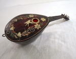 Gracioso alaúde, confeccionado em casco de tartaruga, com incrustações de pássaros e florais com dispositivo musical a corda. Funcionando. Med. 24 cm comprimento.