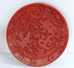Antigo prato em Laca chinesa vermelho , decorado com relevos de dragões, pássaros e folhagens. Bordas recortadas no formato de pétalas. Med. 20 cm diâmetro.