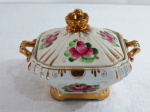 GZHEL RUSSIA - Bomboniere em porcelana quadrangular oitavada, alças laterais, com rico trabalho de flores. Tampa com pega no formato de rosas em douração. Marcado Hand Made in Russia GZHEL. Med. 13 x 18 x 15 cm.