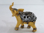 Escultura indiana em resina na cor marfim, representando elefante, dorso e patas com detalhes vazados na cor prata . Med. 12 cm alt x 13 cm comprimento.
