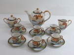 JAPAN- Aparelho de café em porcelana japonesa, decorado com paisagem lacústre e pagodes em policromia e farta douração. Composto de : um bule para café ( 14 cm alt), cremeira, açucareiro e 6 xícaras para café com seus pires. Um pires com bicado na borda.
