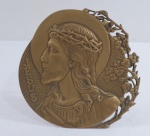 Placa sacra em bronze dourado, com representação de Jesus, em alto relevo. Adornado com ramo de flores. Diam. 18cm.